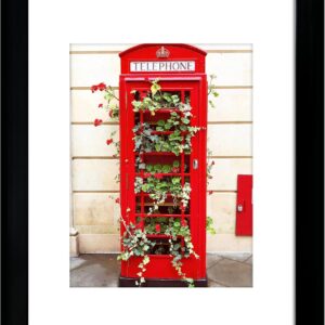 Black Framed Art Print of Red Telephone Booth with Greenery and Red Flowers